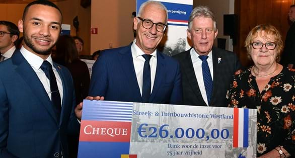 Voorzitter Jan Prins van het Westlands Museum (2e van links) ontvangt de cheque uit handen van de 'ambassadeurs van de Vrijheid' (v.l.n.r.): Divano Dorder, Koos Karssen en Lennie Huizer.